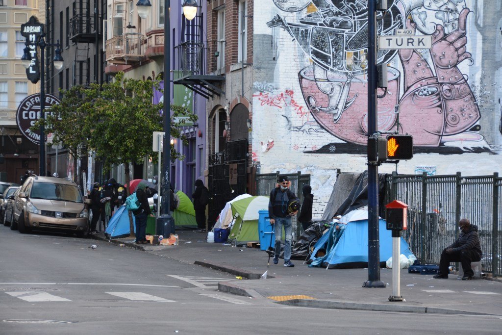 A group of people walking down a busy city streetDescription automatically generated