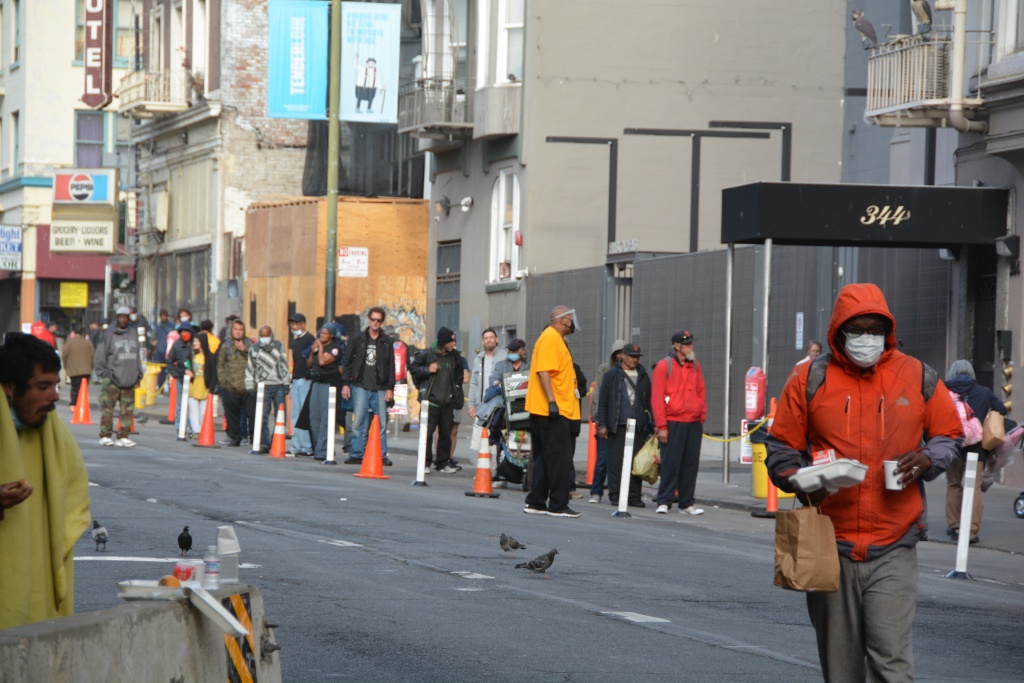 A group of people walking on a city streetDescription automatically generated