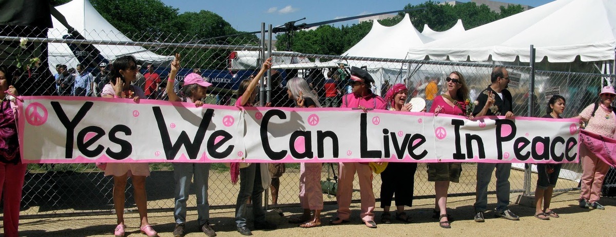 A group of people holding a sign Description automatically generated with medium confidence