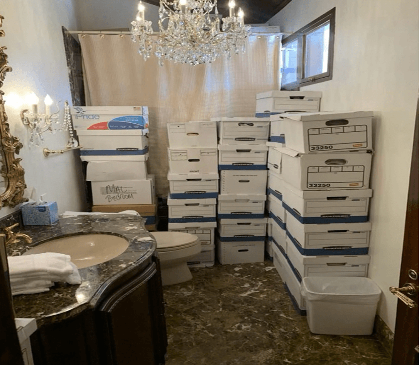 A bathroom with a chandelier and boxes Description automatically generated with medium confidence