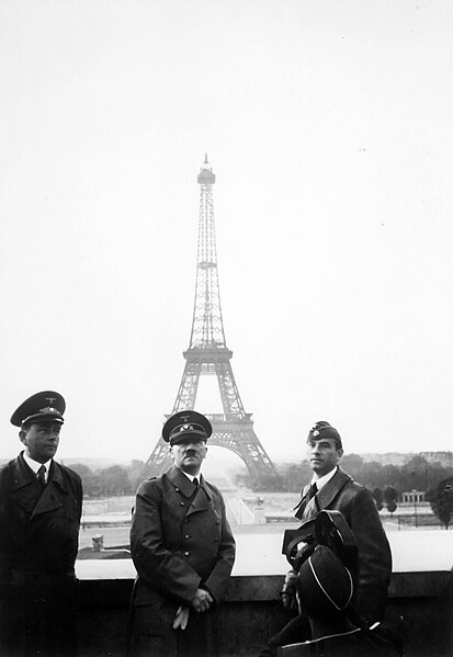 A group of men in uniform standing in front of the eiffel tower

Description automatically generated