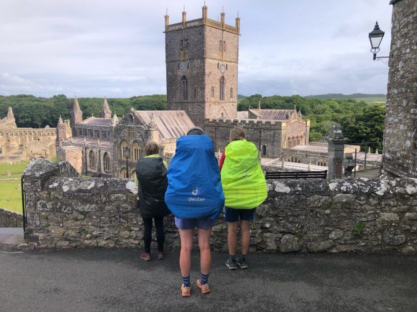 A group of people standing on a ledge looking at a stone wall AI-generated content may be incorrect.