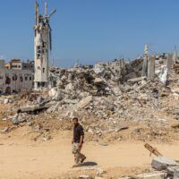 A person walking in a dirt area with rubble AI-generated content may be incorrect.