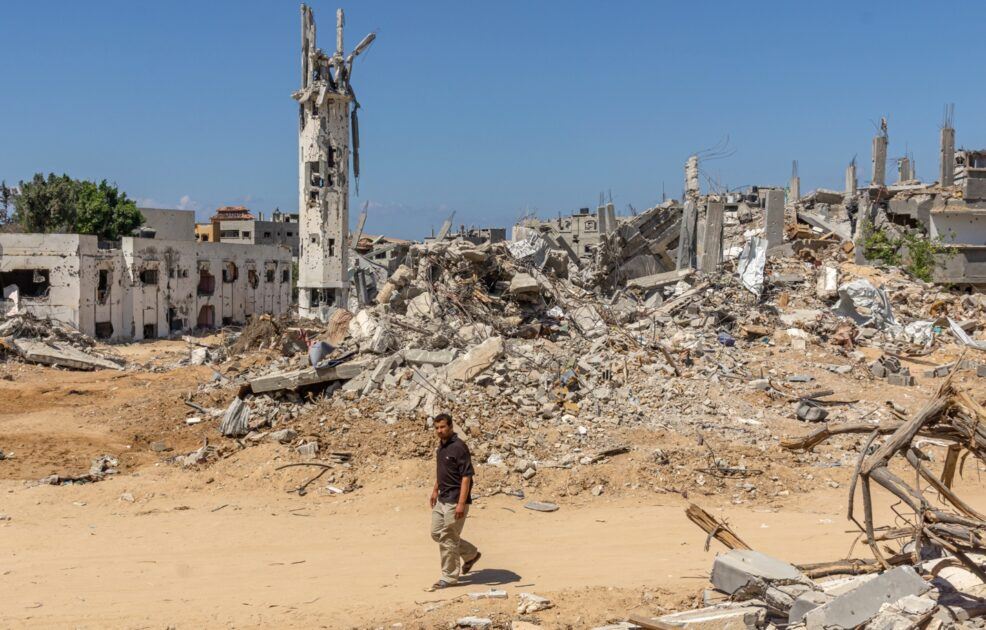 A person walking in a dirt area with rubble AI-generated content may be incorrect.
