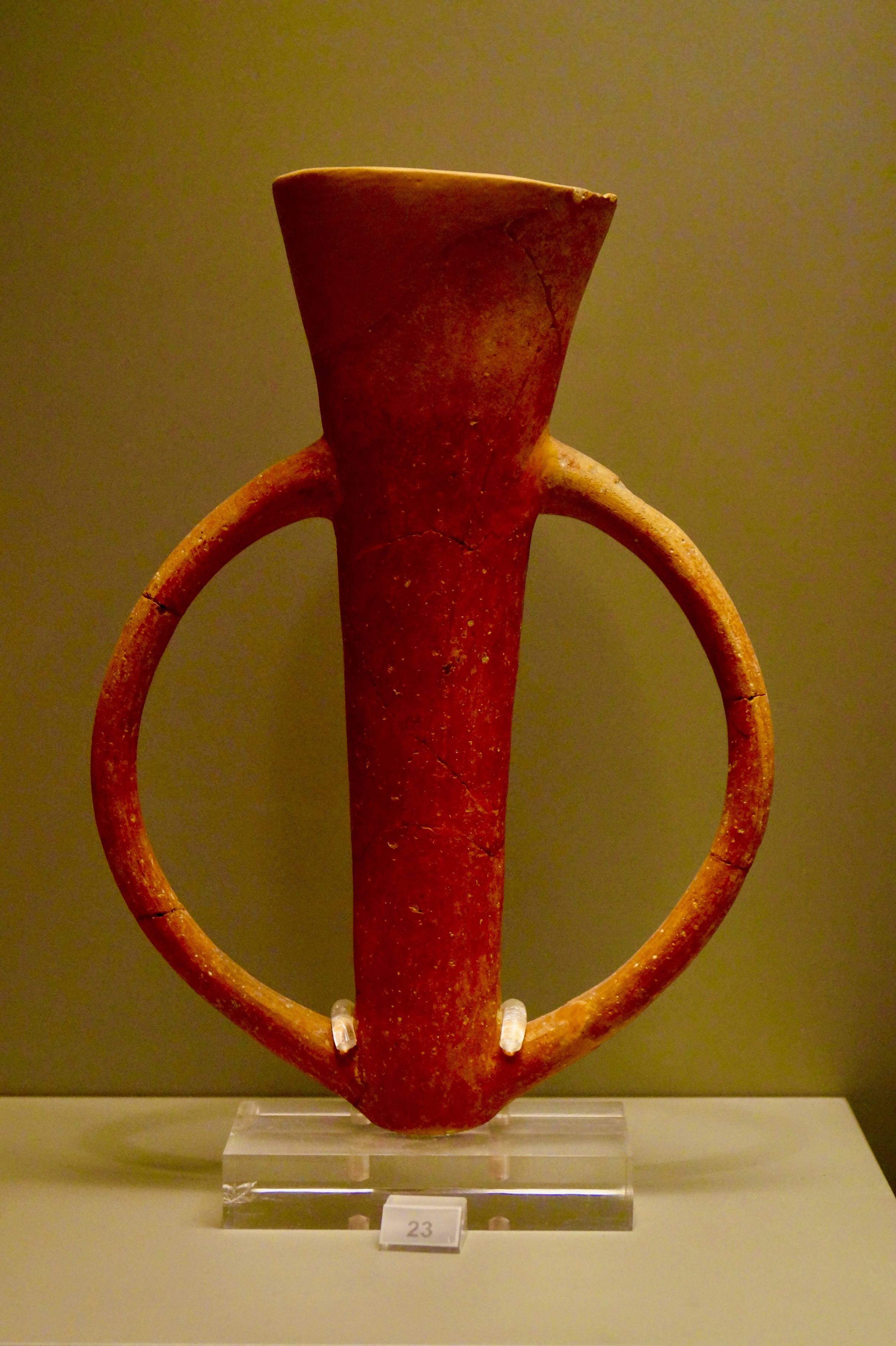 A red vase with two handles AI-generated content may be incorrect.