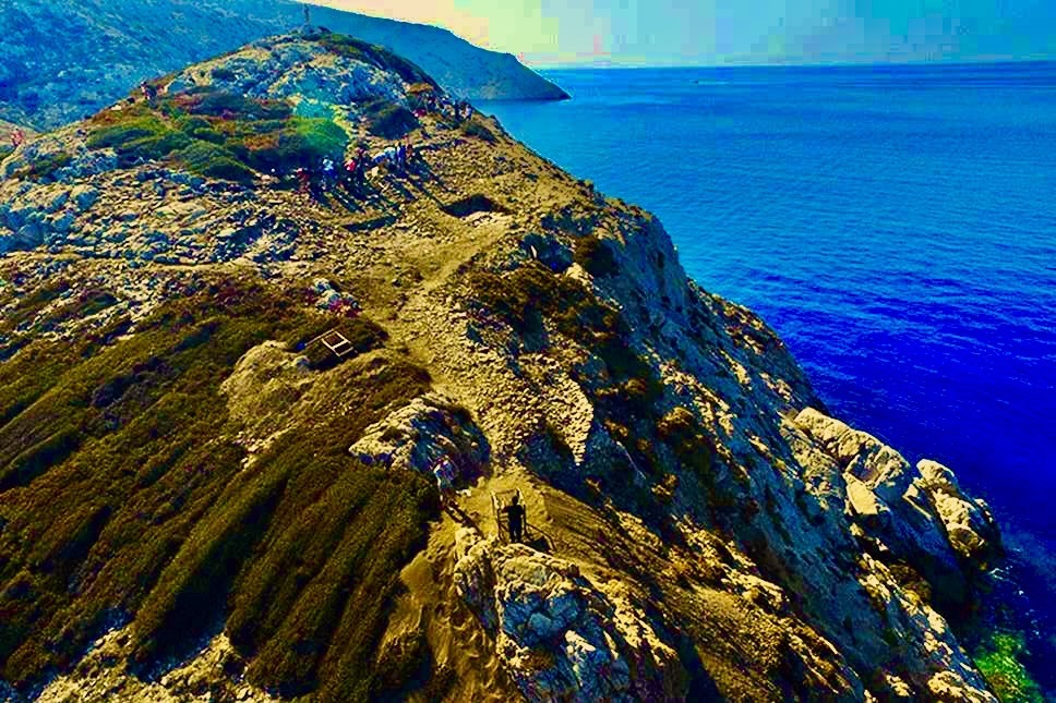 A rocky cliff with people walking on it AI-generated content may be incorrect.