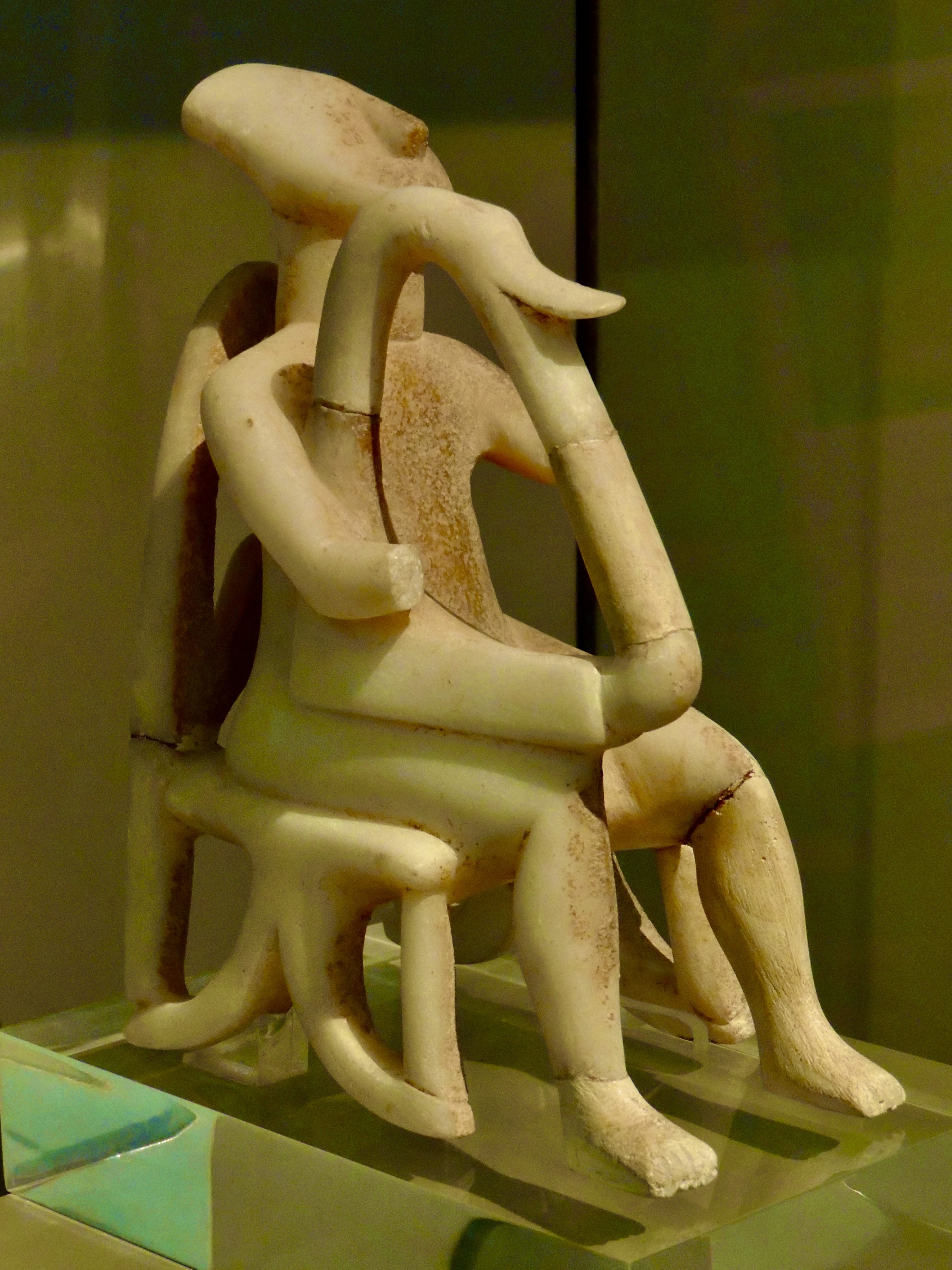 A statue of a person sitting on a chair AI-generated content may be incorrect.