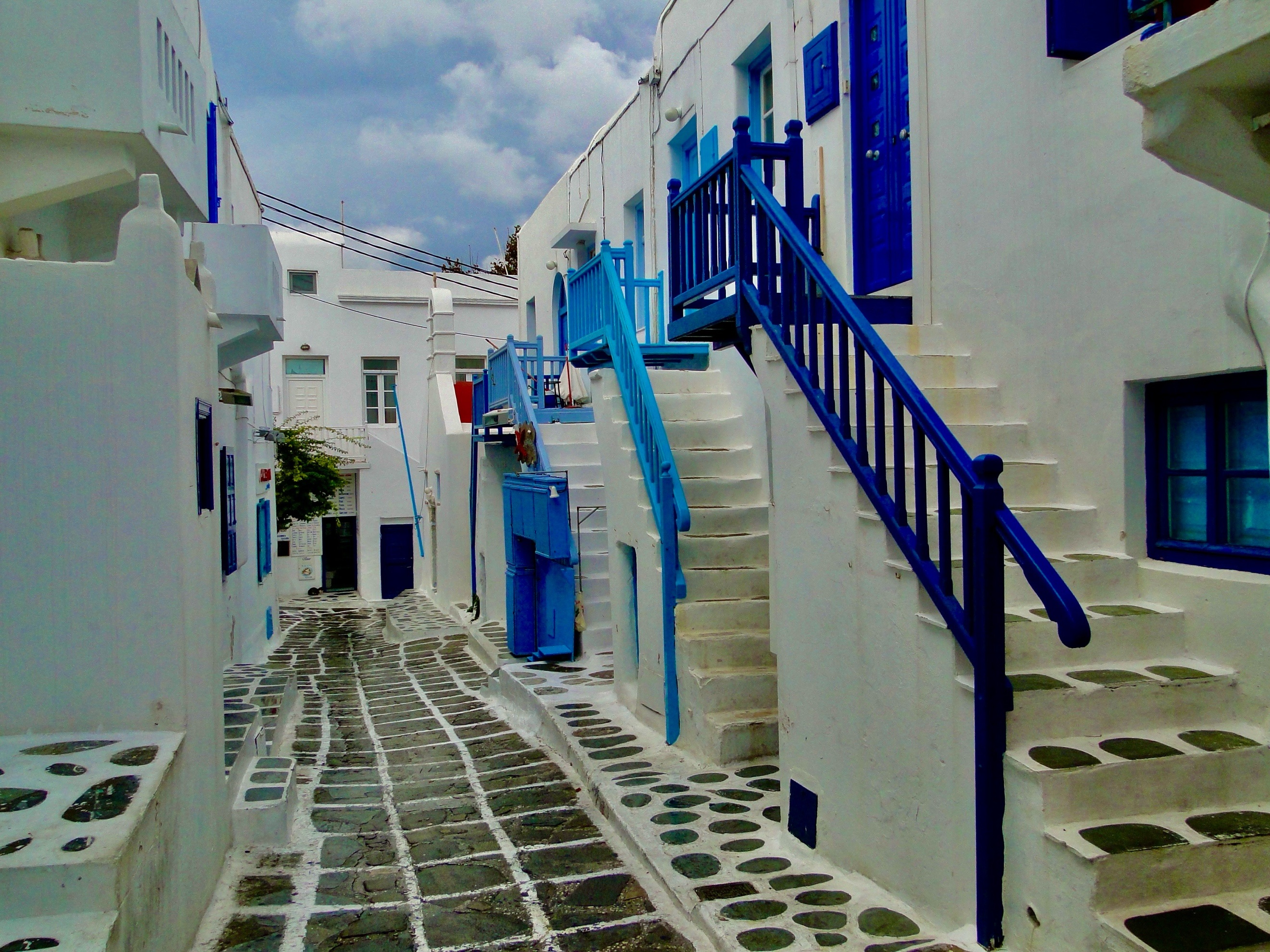 A white and blue staircases in a narrow alleyAI-generated content may be incorrect.