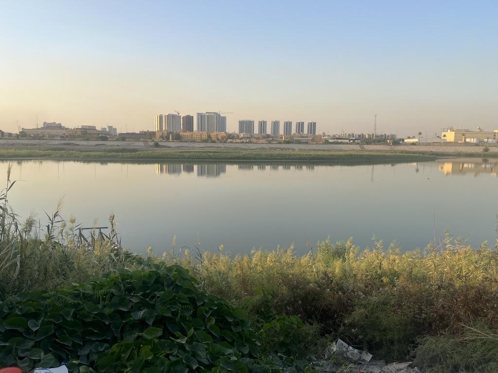 A body of water with buildings in the backgroundAI-generated content may be incorrect.