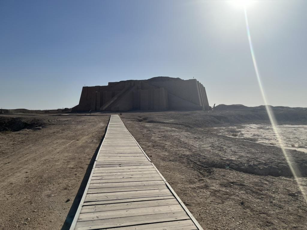 A wooden walkway leading to a buildingAI-generated content may be incorrect.