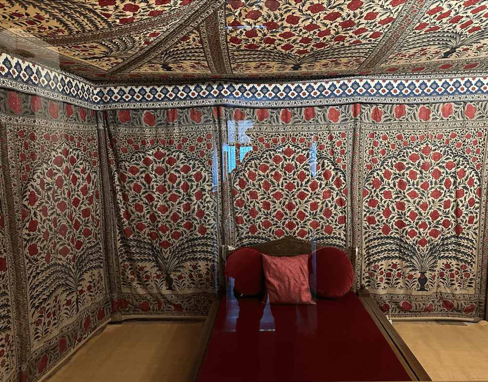 A bed with pillows in a room with a curtain AI-generated content may be incorrect.