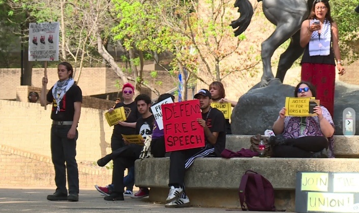 A group of people sitting on a bench holding signs AI-generated content may be incorrect.